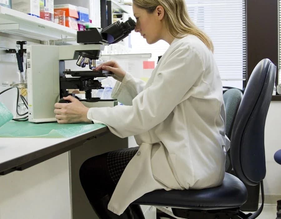 Scientist at microscope analyzing water samples